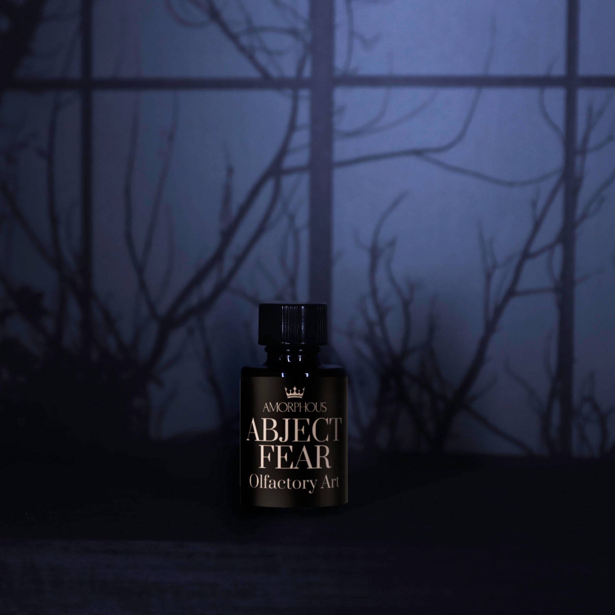 Perfume bottle labeled 'ABJECT FEAR' against a dark, forest-like background