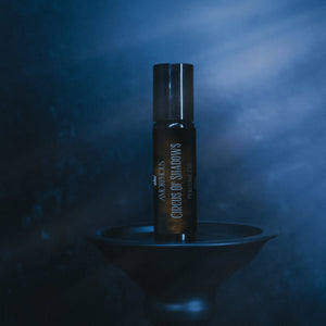 Perfume bottle labeled 'Circuses of Shadows' on a dark background
