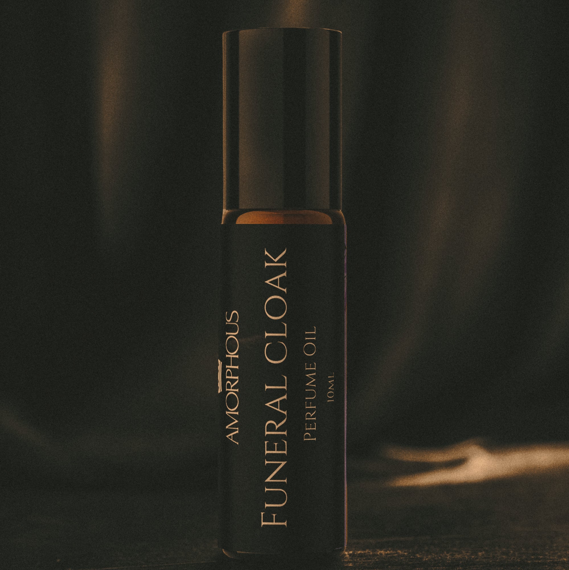 Amorphous Funeral Cloak perfume oil bottle on a dark background