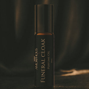Amorphous Funeral Cloak perfume oil bottle on a dark background