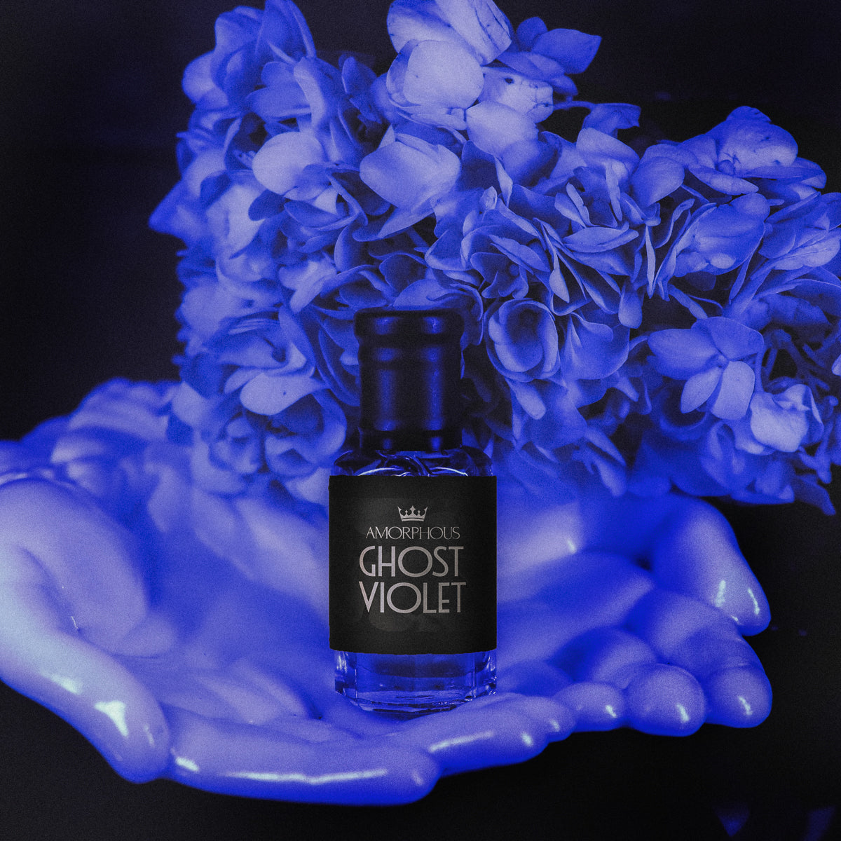 Perfume bottle labeled 'Ghost Violet' held in hands with blue glowing flowers in the background