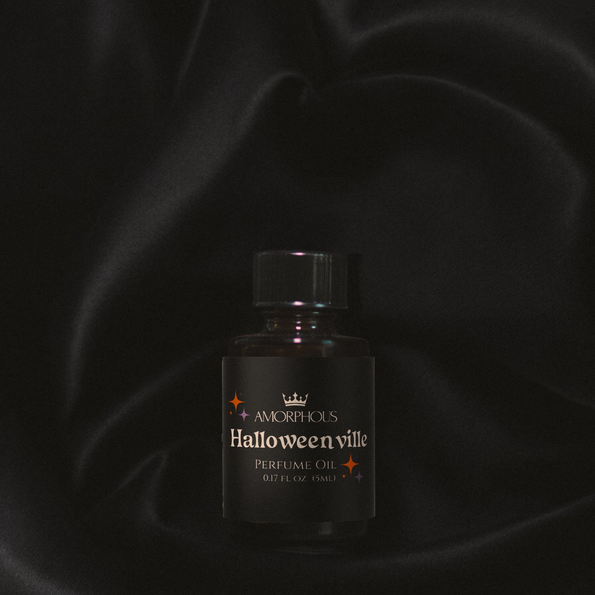Perfume bottle labeled 'Halloween ville' by Amorphous on a dark background