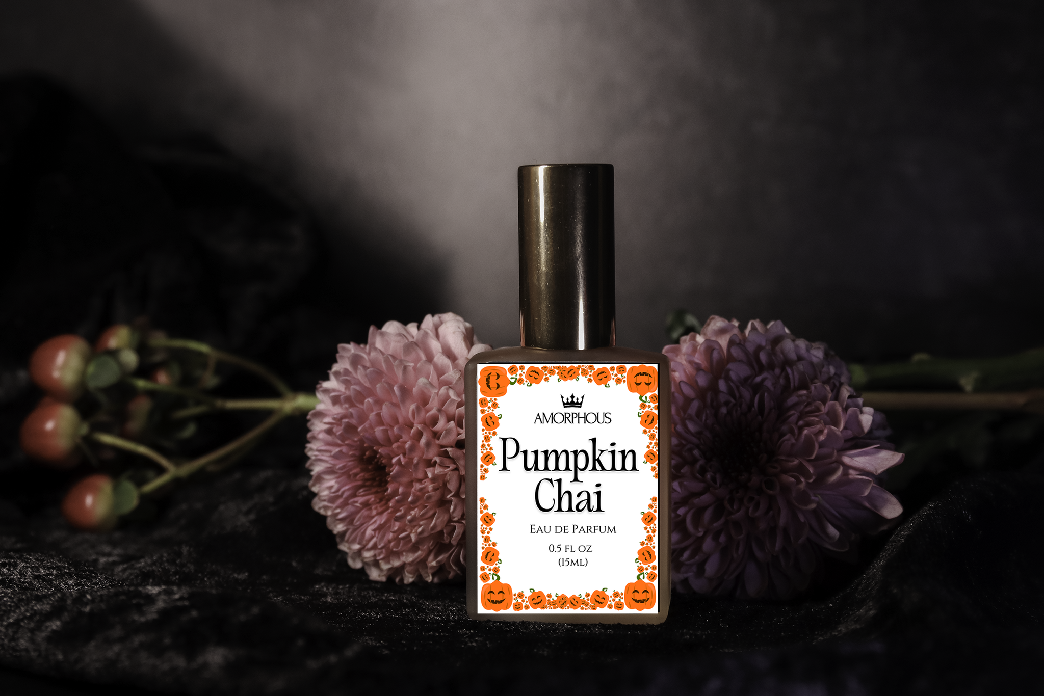 Amorphous Pumpkin Chai perfume bottle with flowers on a dark background