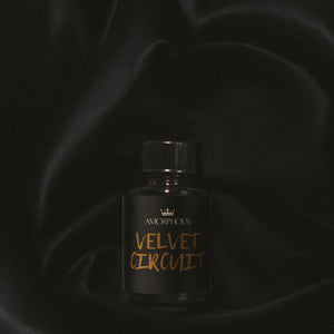 Black perfume bottle labeled 'Velvet Circuit' by Amorphous on a dark background