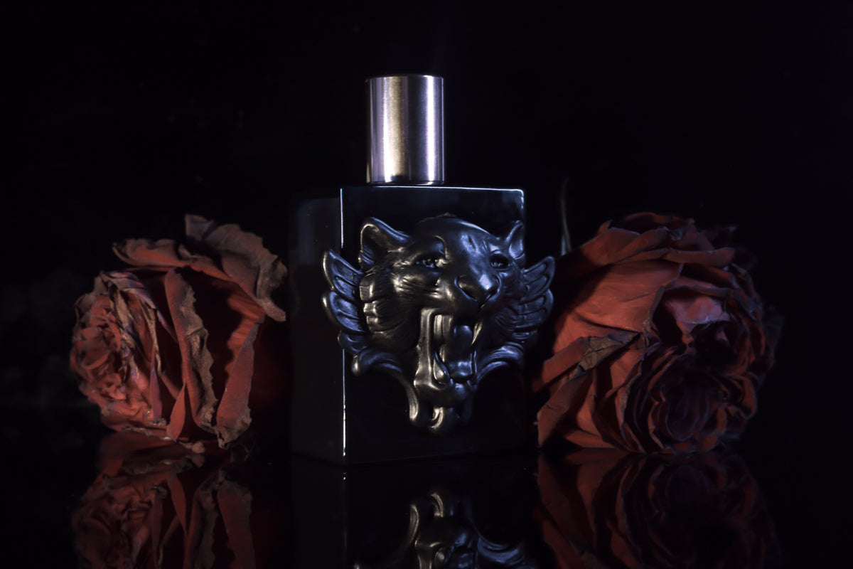 A bottle of witchy fragrance and red roses