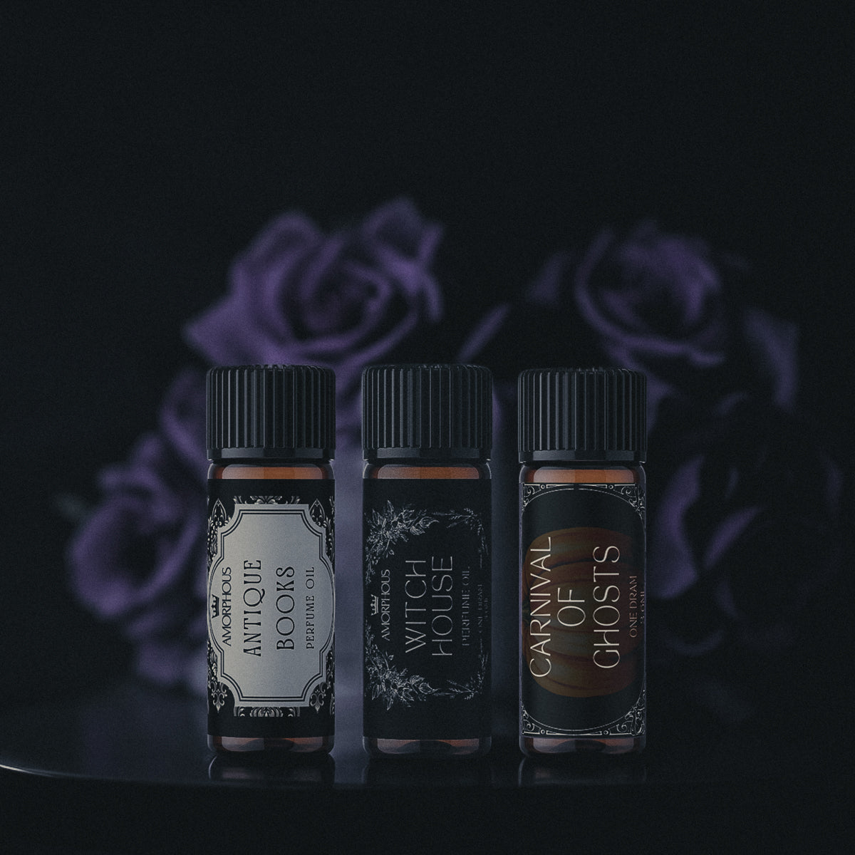 Three small bottles with labels against a dark background with purple roses.