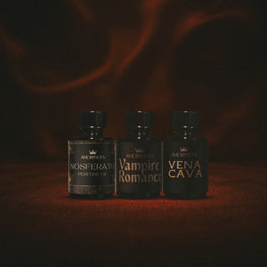 Three perfume bottles labeled 'Nosferatu', 'Vampire Romance', and 'Vena Cava' on a dark background.